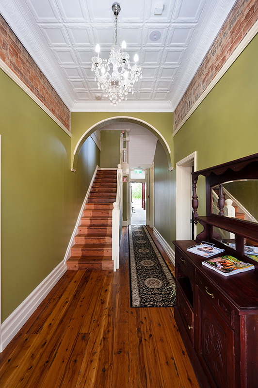 Hallway with green walls and wooden floors