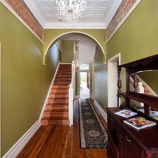 Hallway with green walls and wooden floors